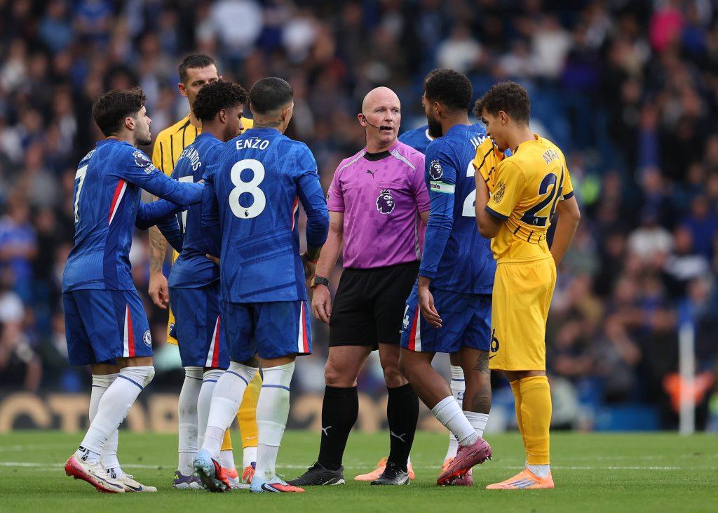 Referee Simon Hooper being surrounded by Chelsea players