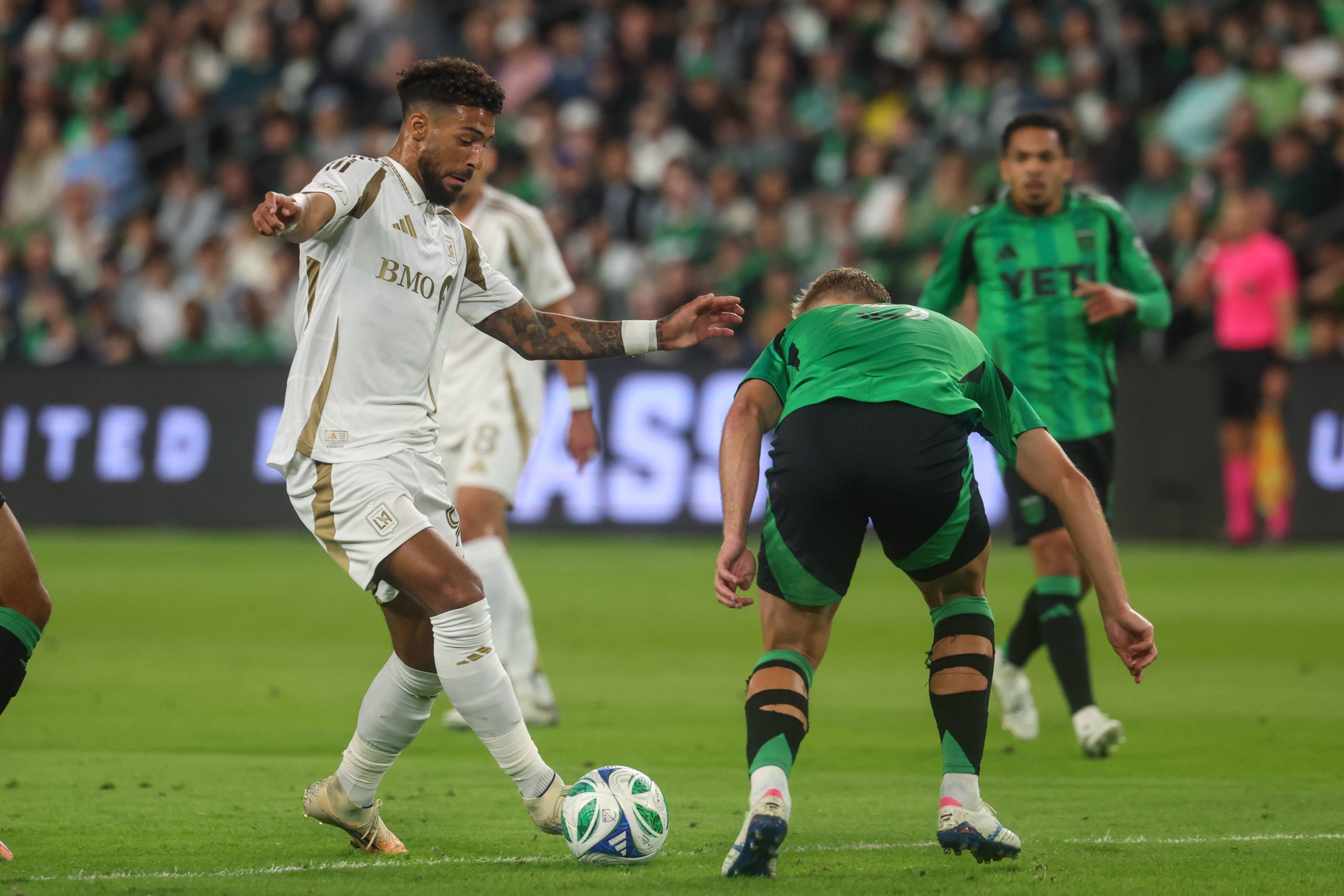 Denis Bouanga controls the ball just inside the box while being defended by defender Oleksandr Svatok during MLS playoff match between Austin FC and Los Angeles FC