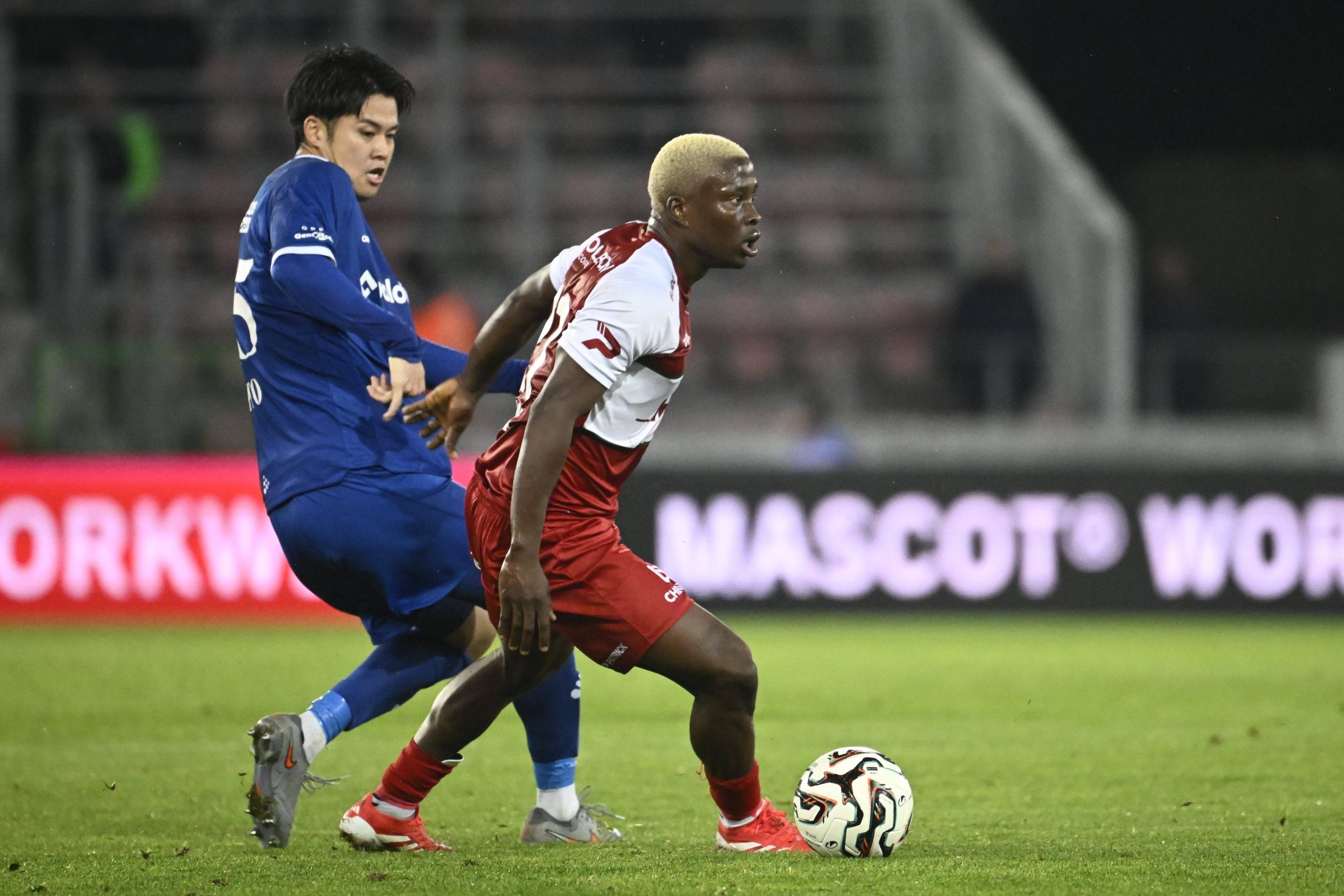 Nnadi Tochukwu and Itoh Atsuki battle for the ball during the Jupiler Pro League match between SV Zulte Waregem and KAA Gent