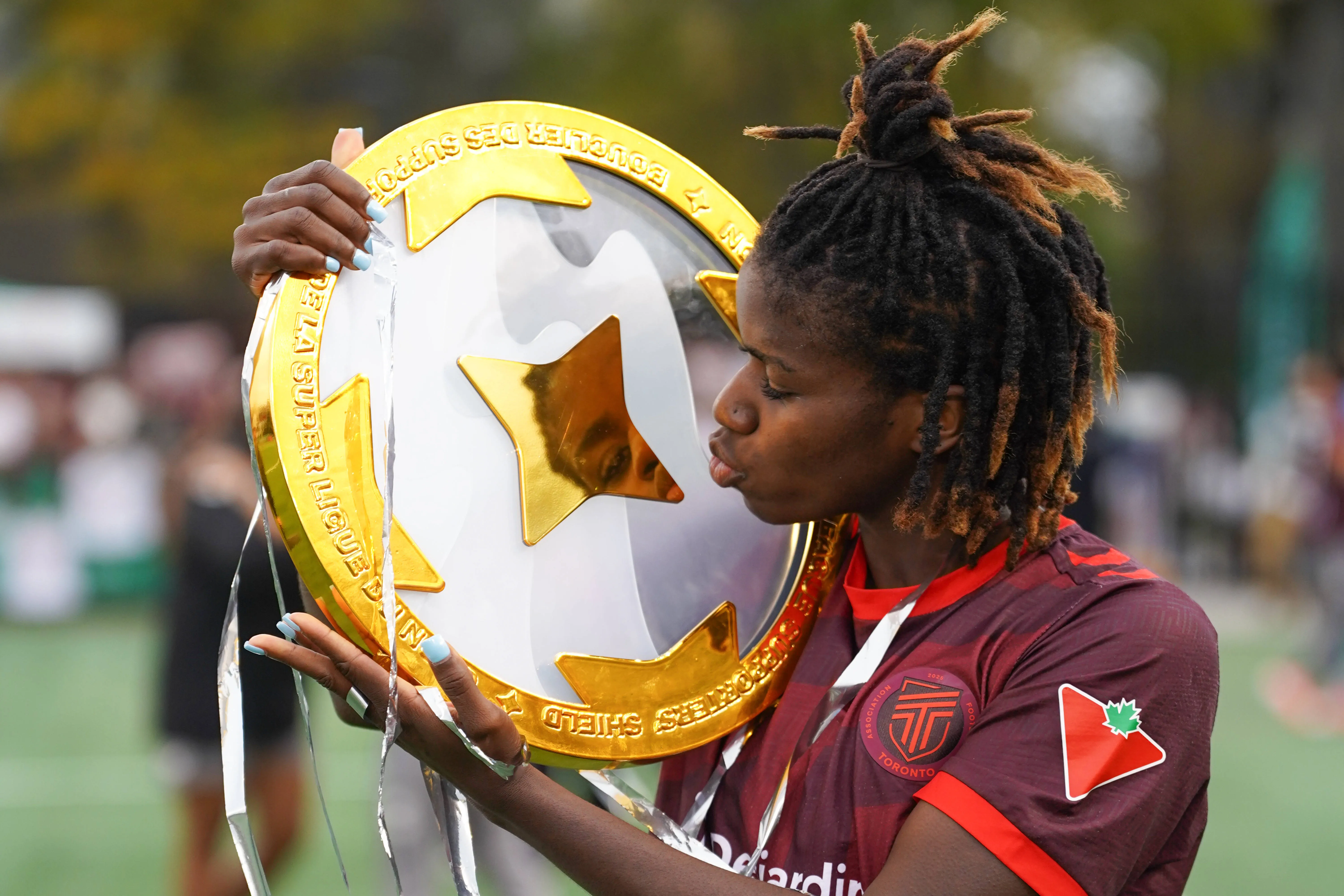 Esther Okoronkwo of AFC Toronto kisses the Supporters Shield trophy