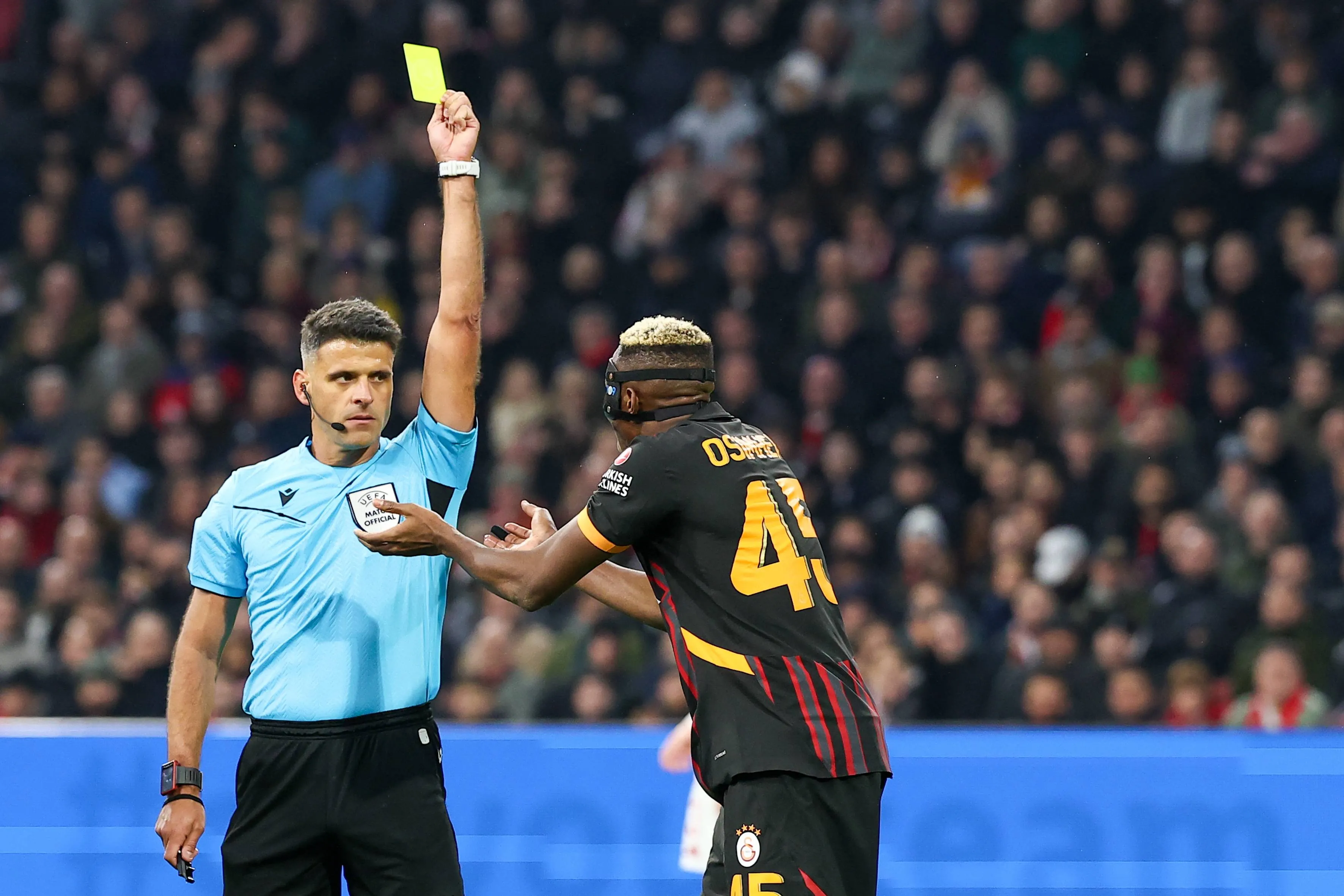 Referee Jesus Gil Manzano shows yellow card to Galatasaray player Victor Osimhen