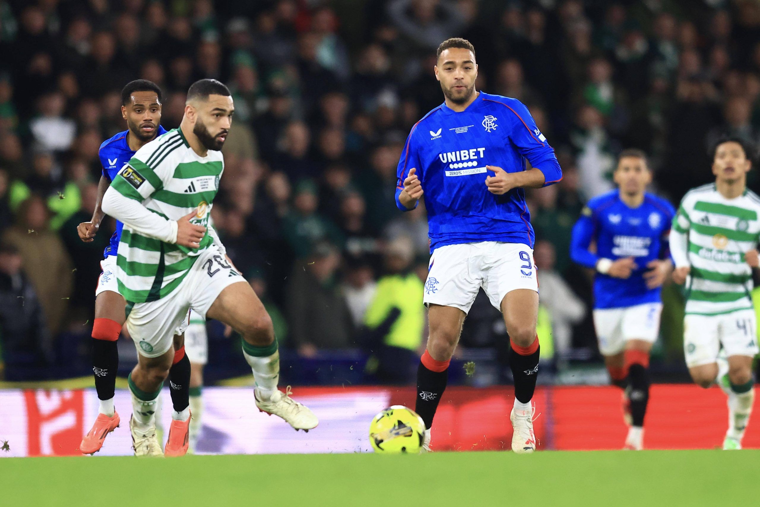 Cyriel Dessers of Rangers hits a pass while Cameron Carter-Vickers of Celtic tries to close him down