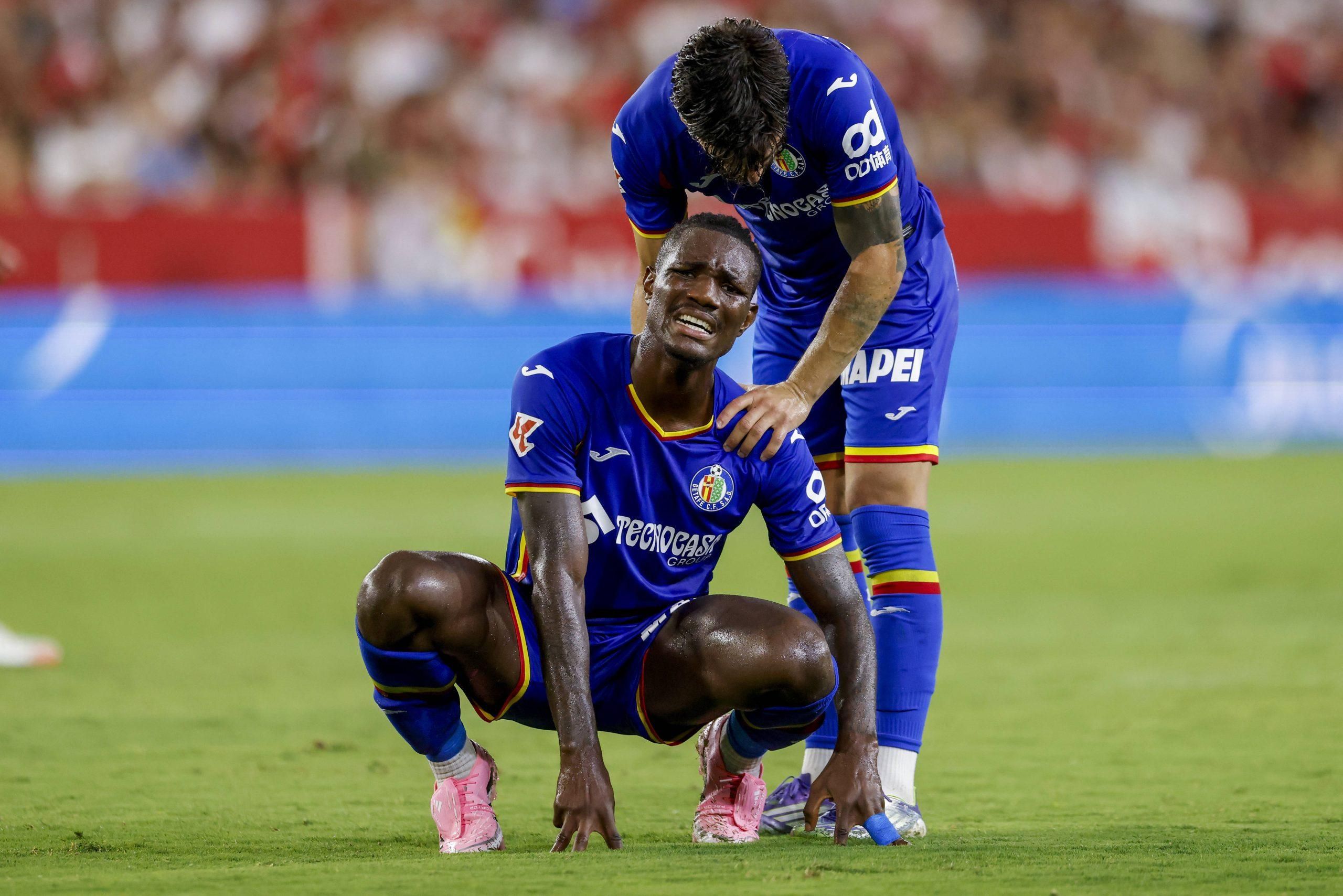 Christantus Uche lies injured on the field during the La Liga EA Sports match between Sevilla FC and Getafe CF at Ramon Sanchez Pizjuan