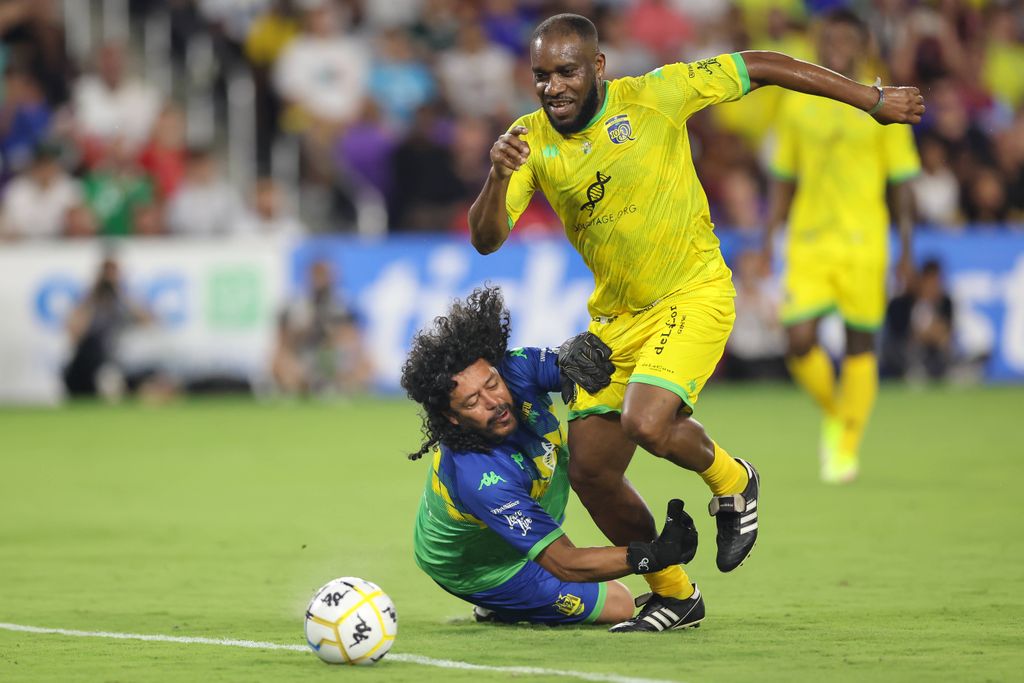 JJ Okocha drives the ball past Carlos Higuita for a goal during the beautiful game soccer match