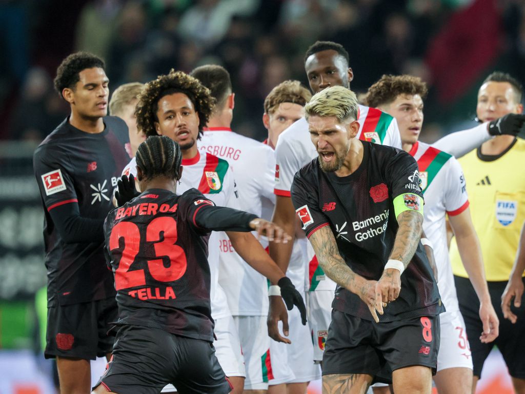 Robert Andrich pushes his own teammate Nathan Tella aside after he got into a discussion during the Bundesliga match FC Augsburg Bayer 04 Leverkusen