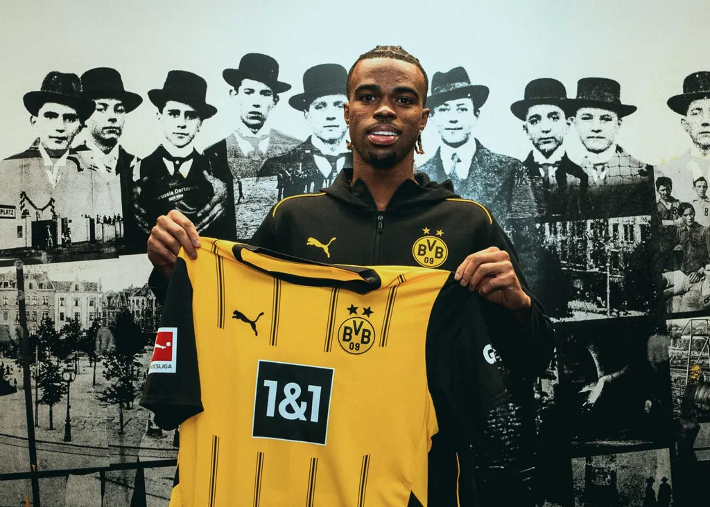 Carney Chukwuemeka holding a Borussia Dortmund jersey after he signed for the Black and Yellows on loan from Chelsea