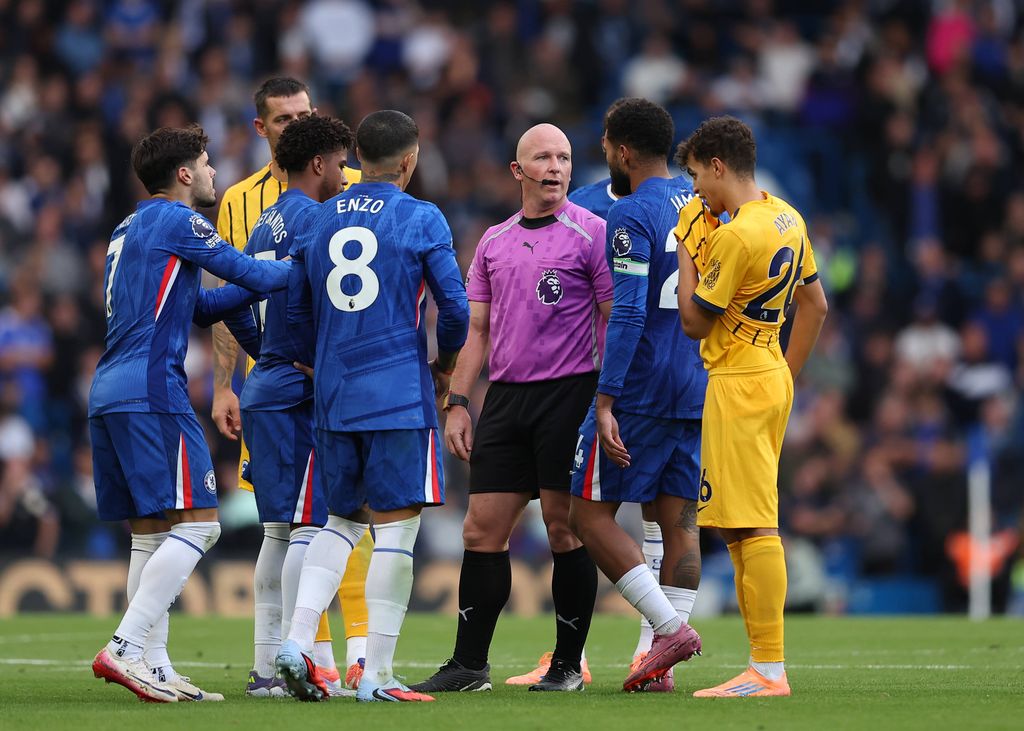Referee Simon Hooper being surrounded by Chelsea players