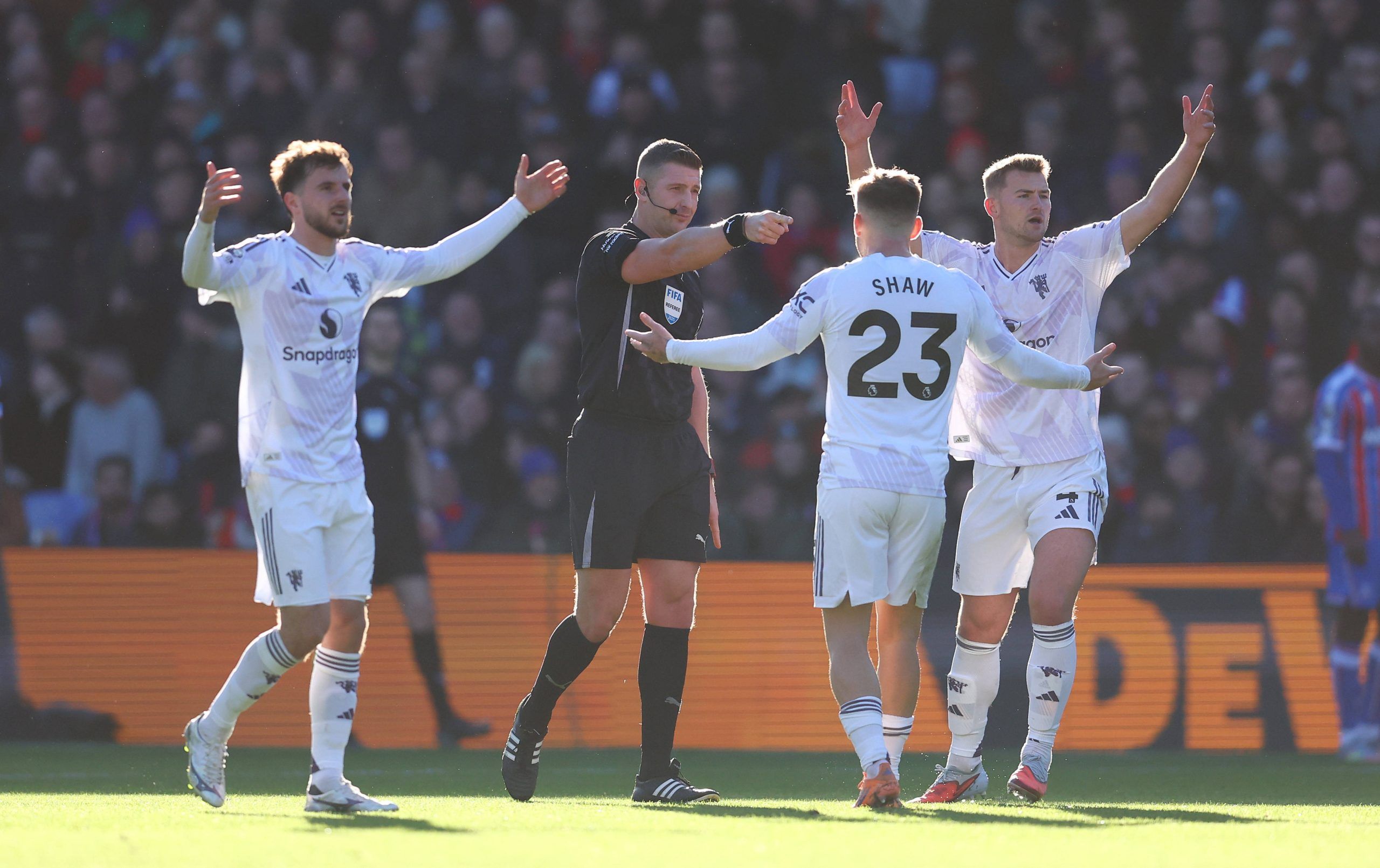 Man Utd players appeal after referee Robert Jones makes the decision for Jean-Philippe Mateta to retake a penalty after it was deemed he kicked the ball twice during the Crystal Palace vs Manchester United