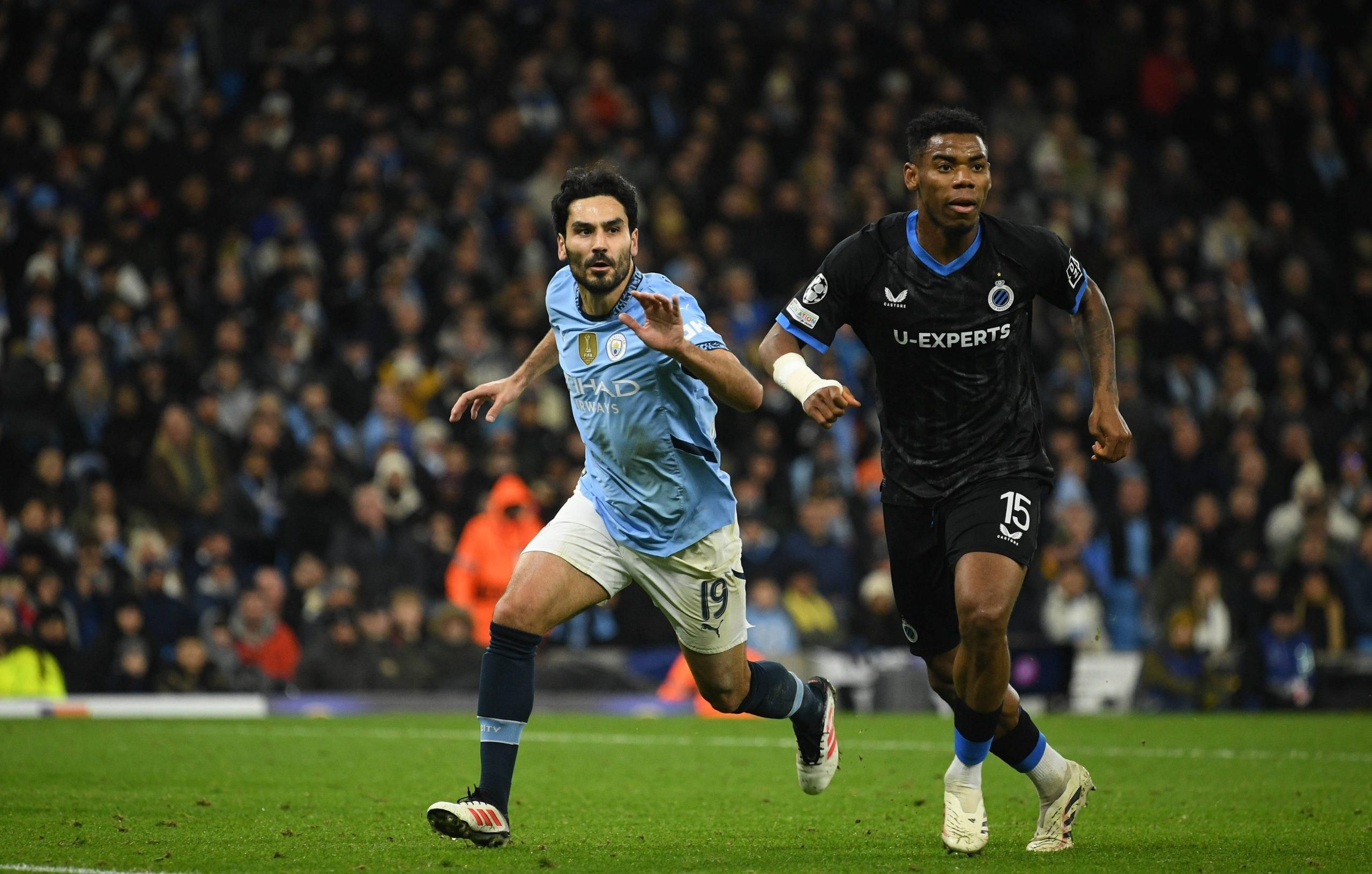Älkay GündoÄüan, Raphael Onyedika in action during the UEFA 2024 Champions League group match between Manchester City and Club Brugge