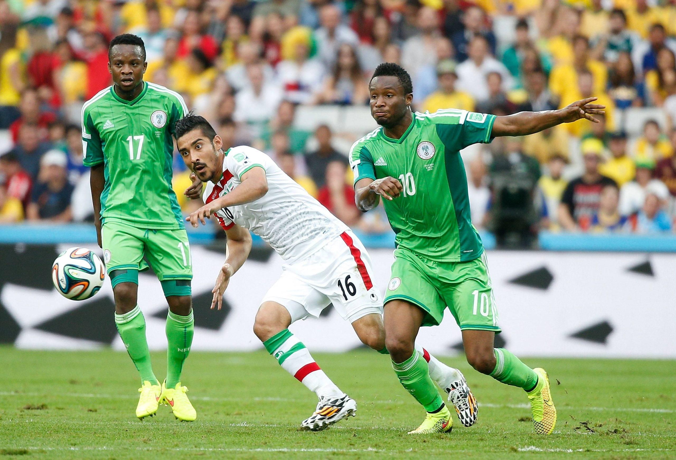 Iran s Reza Ghoochannejad (C) vies with Nigeria s Ogenyi Onazi (L) and Mikel Obi (R) during a Group F match between Iran and Nigeria of 2014 FIFA World Cup