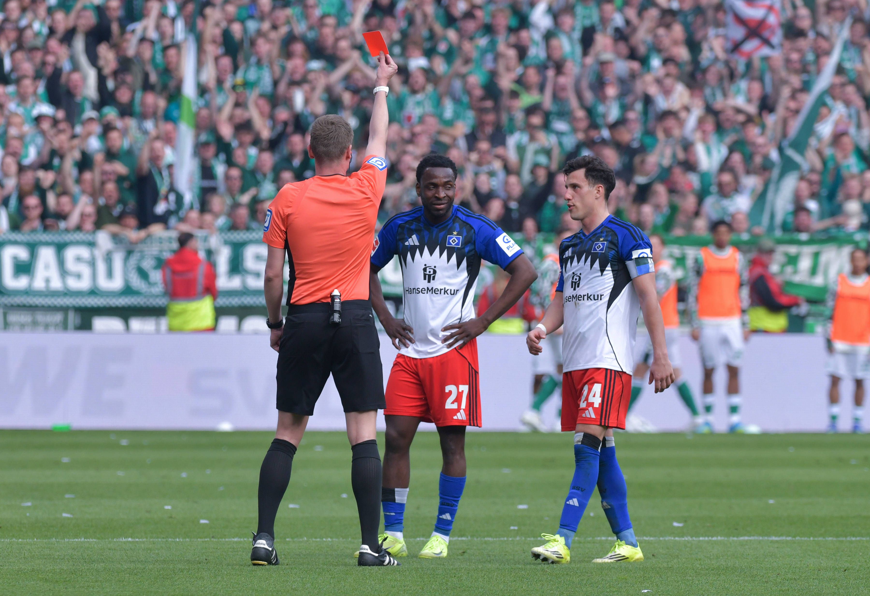 Referee Florian Exner issues a red card for violent misconduct to Philip Otele of Hamburg