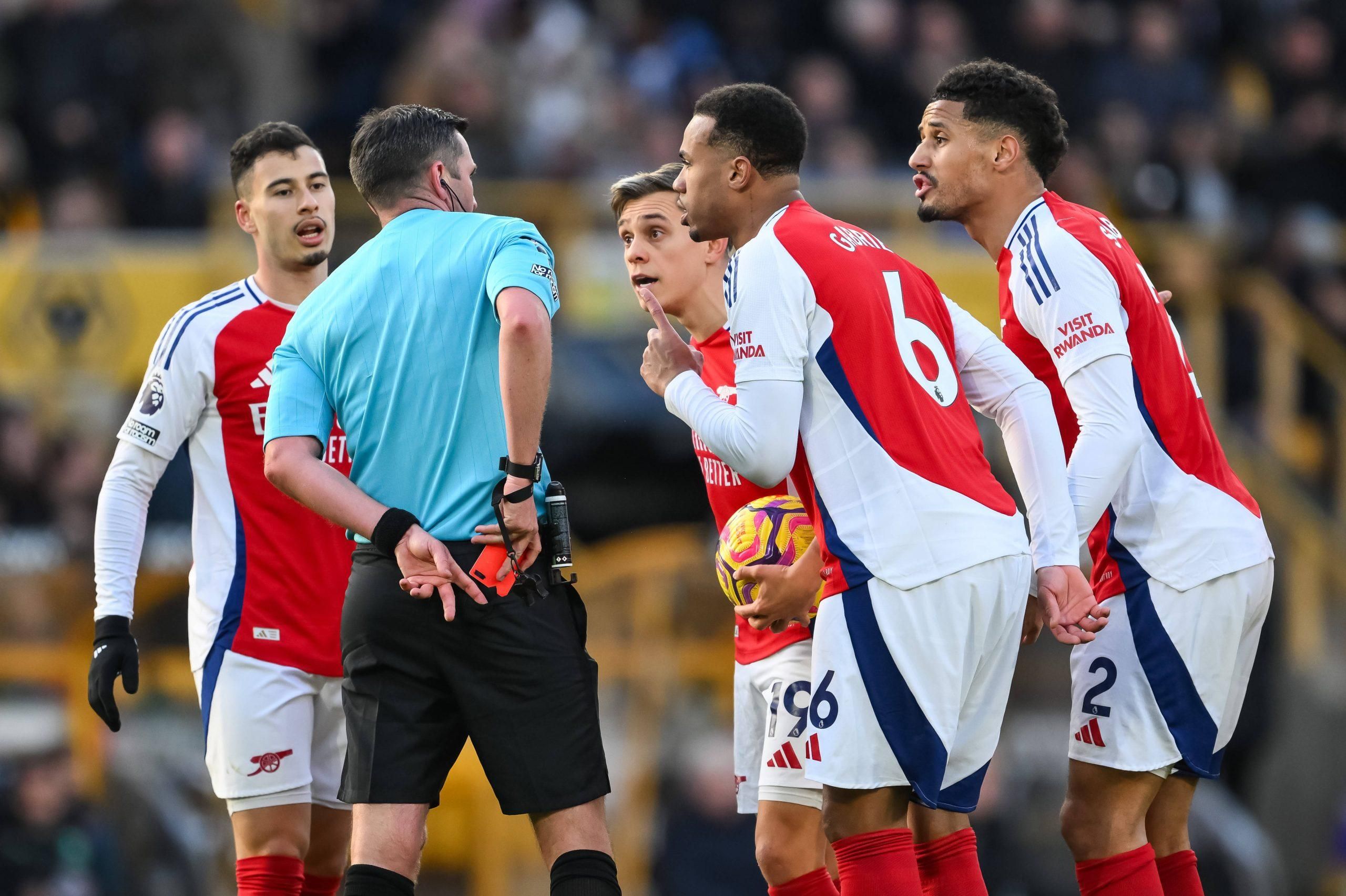 Arsenal players surround Referee Michael Oliver