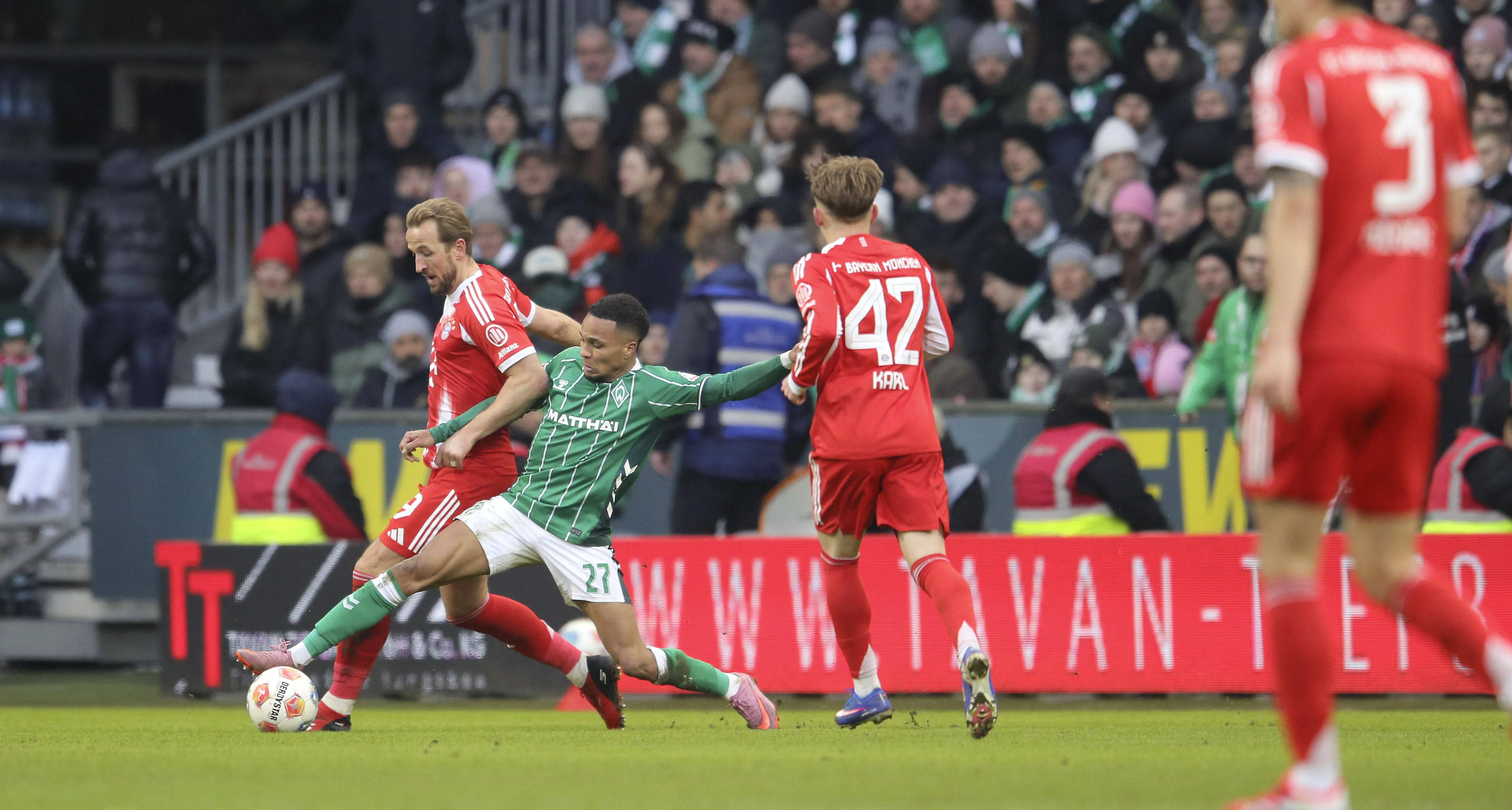 Felix Agu battles for the ball with Harry Kane in Werder Bremen's loss to Bayern Munich