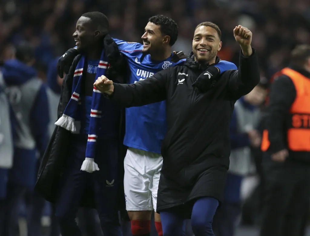 Mohammed Diomande, Jeff and Cyriel Dessers of Rangers celebrate after beating Fenerbahce 3-2 on penalties