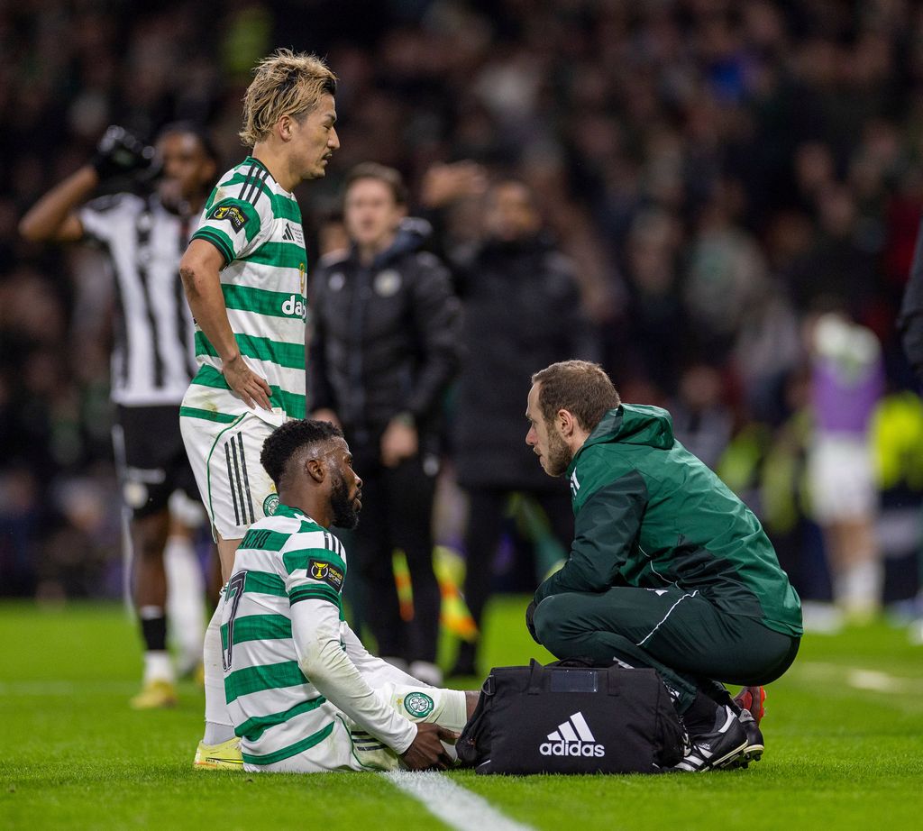 Kelechi Iheanacho of Celtic feels his hamstring as the medical team check him over