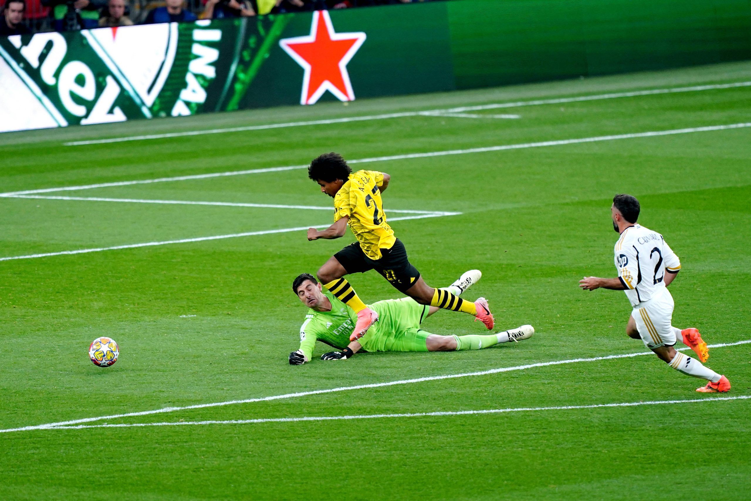 Dortmund s Karim Adeyemi gets around Real Madrid goalkeeper Thibaut Courtois during the UEFA Champions League final at Wembley Stadium in London