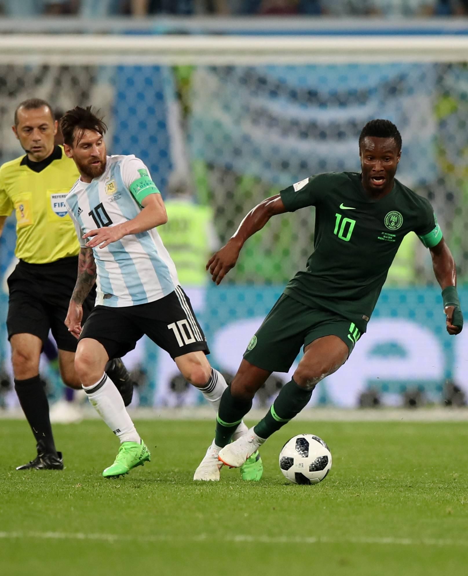 John Obi Mikel (R) of Nigeria vies with Lionel Messi (C) of Argentina