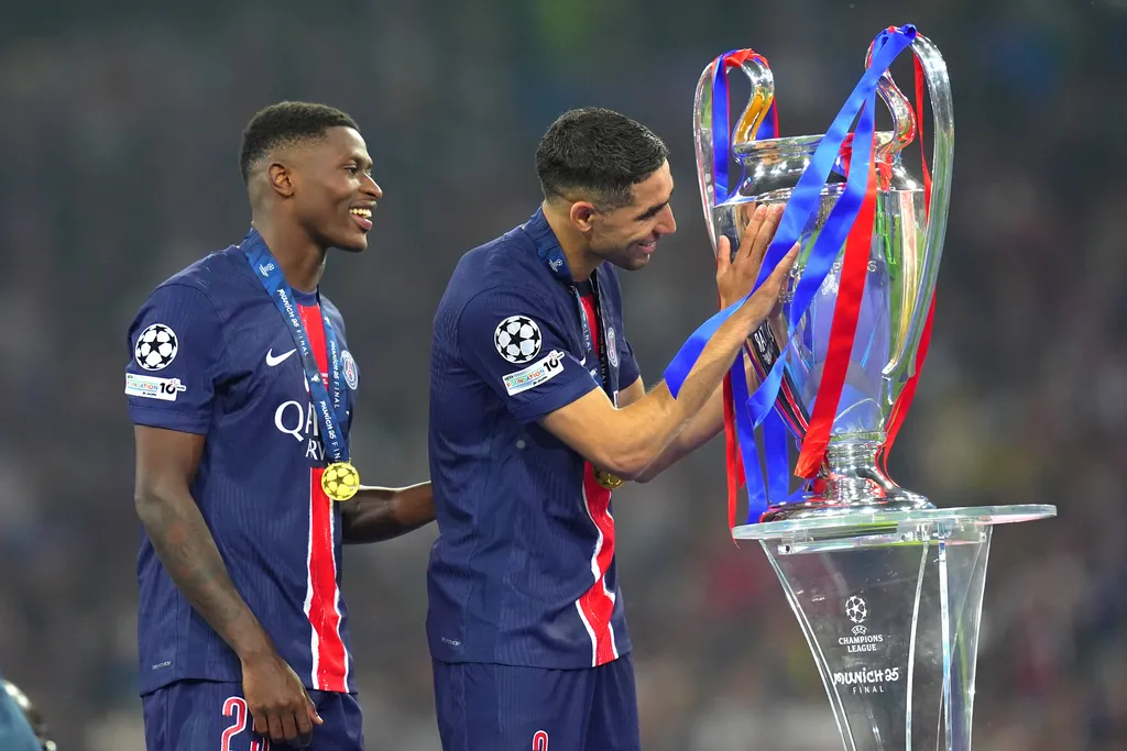 Achraf Hakimi and Nuno Mendes celebrate winning the UCL trophy with PSG