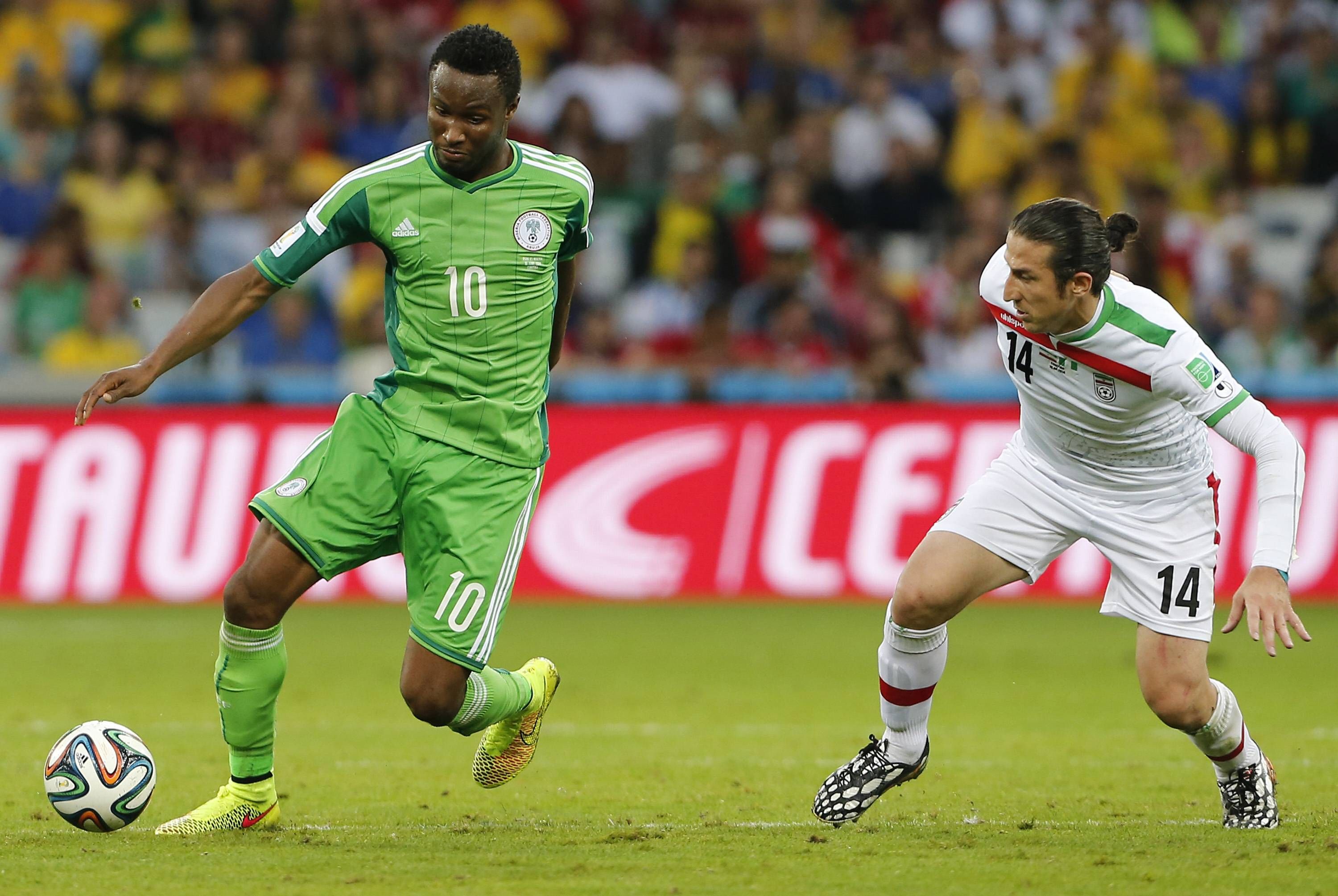 Mikel Obi vies with Iran's Andranik Timotian