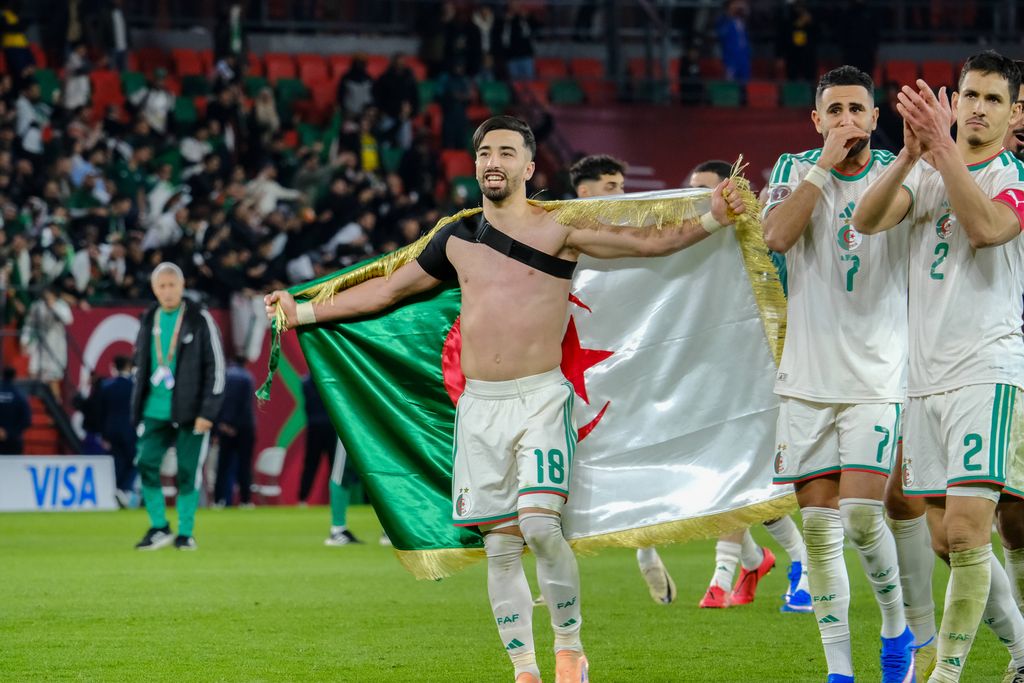 Algerian players celebrate AFCON Round of 16 victory with national flag