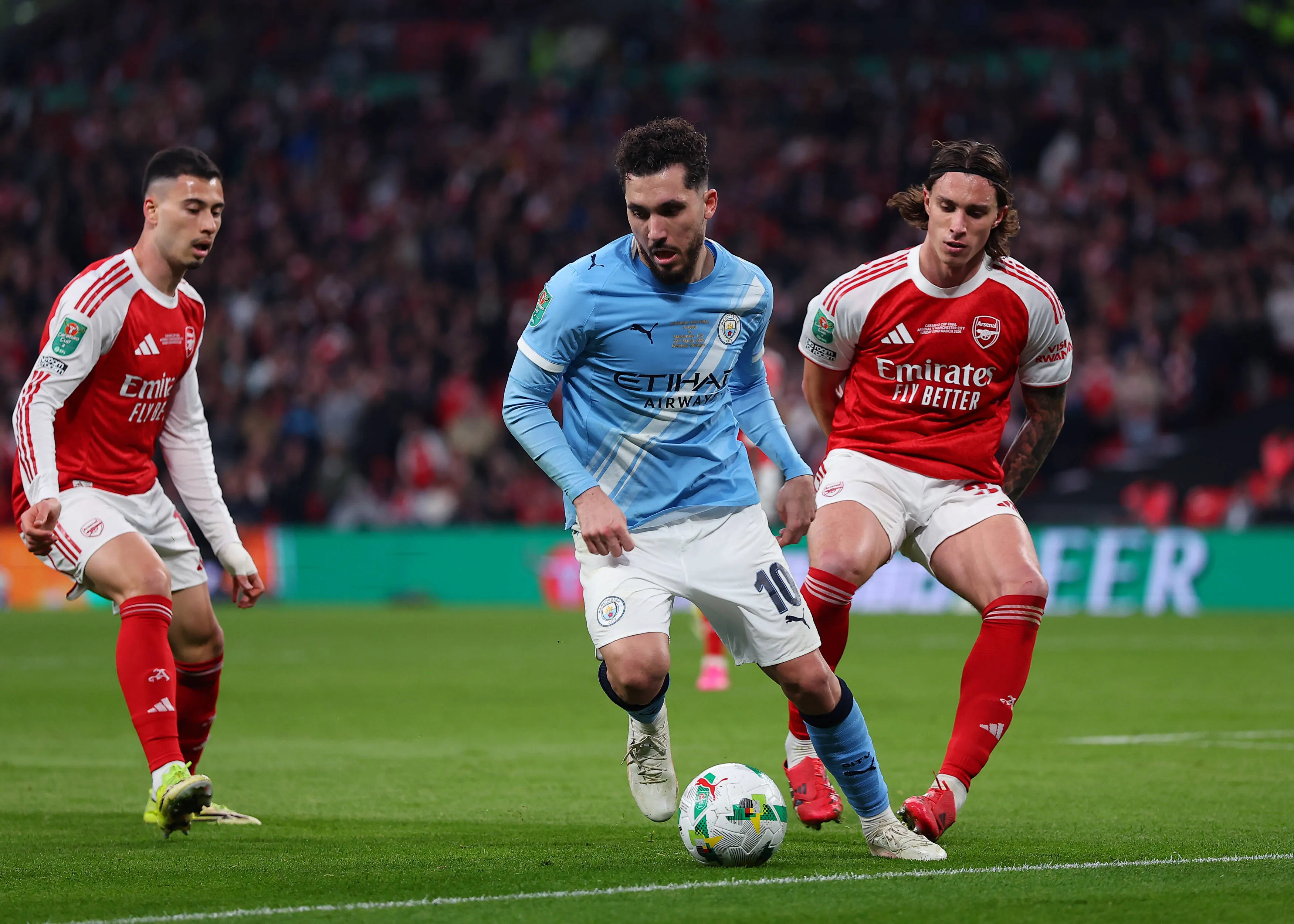  Arsenal versus Manchester City Rayan Cherki of Manchester City under pressure from Riccardo Calafiori and Gabriel Martinelli of Arsenal
