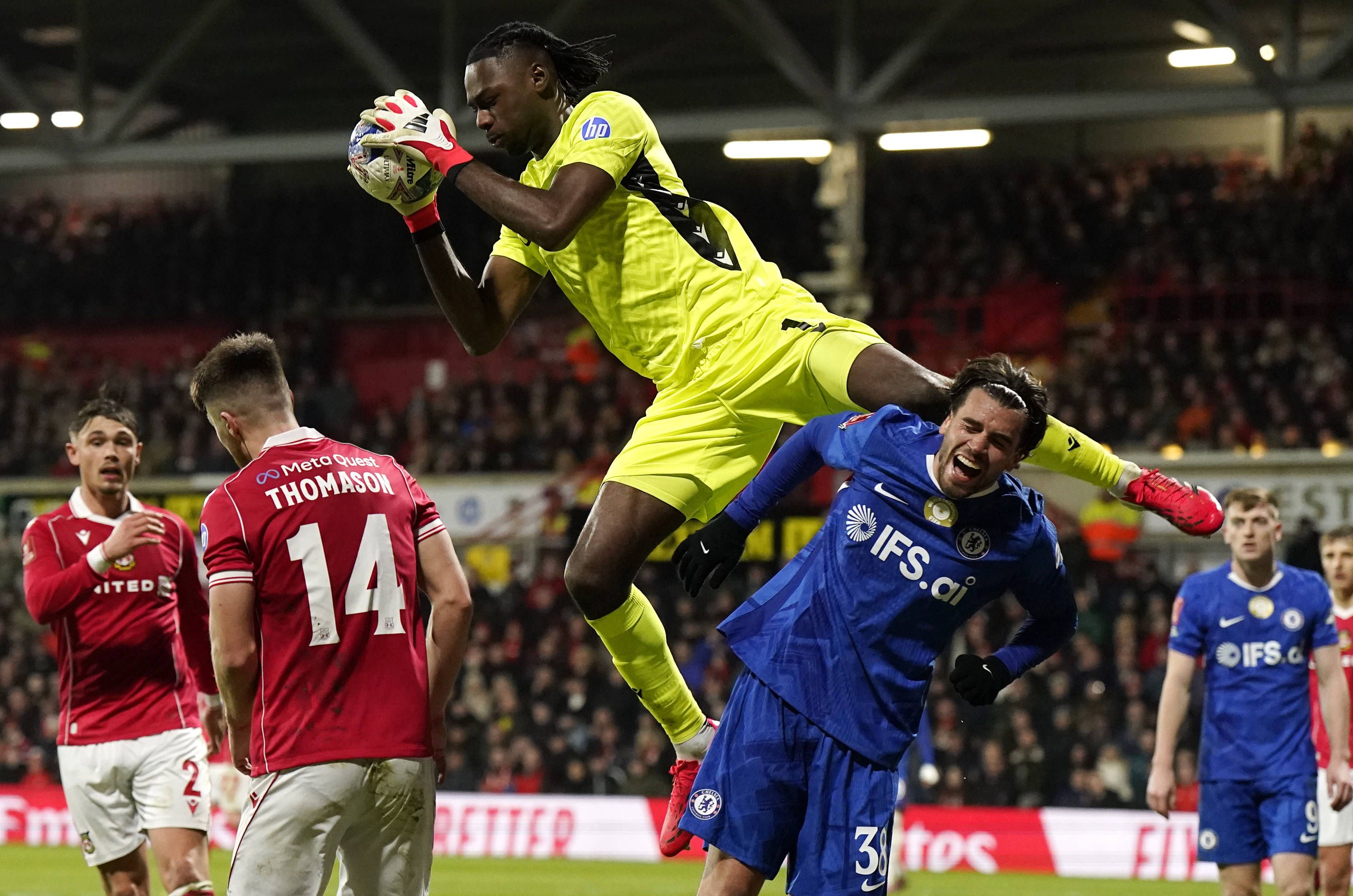 Wrexham goalkeeper Arthur Okonkwo collects the ball above Marc Guiu of Chelsea
