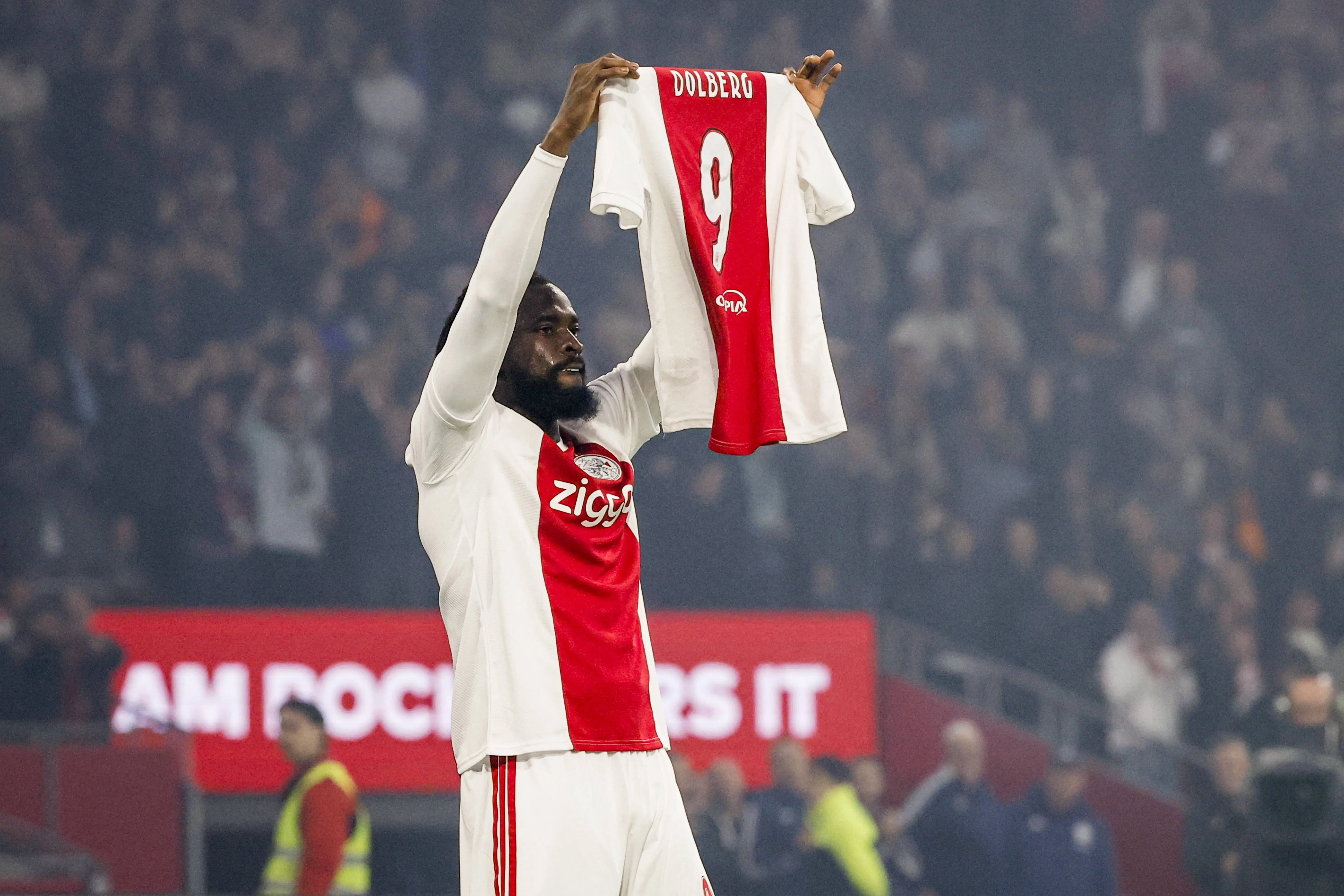Tolu Arokodare celebrates with the shirt of the injured Kasper Dolberg