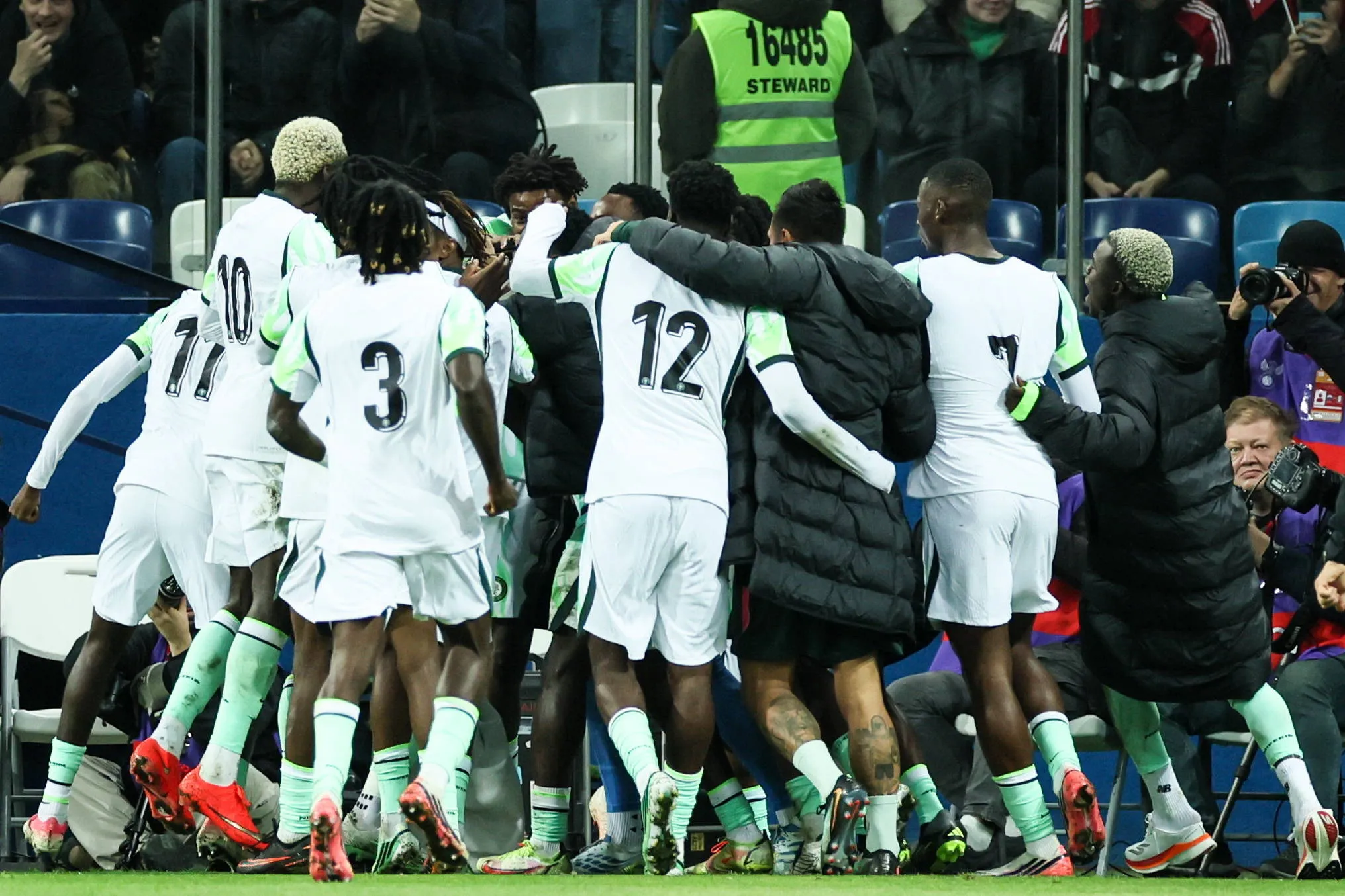 Super Eagles players and coaching staff celebrate Akor Adams' late goal