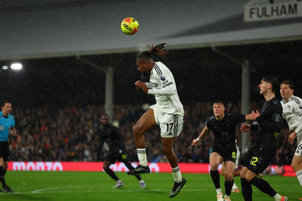Alex Iwobi heads the ball out into midfield