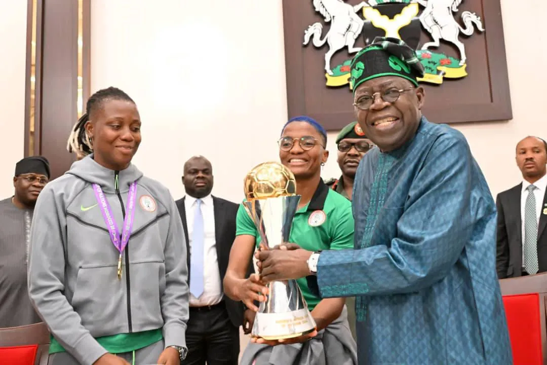 President Bola Tinubu holds the WAFCON trophy during a presidential reception for the Super Falcons of Nigeria