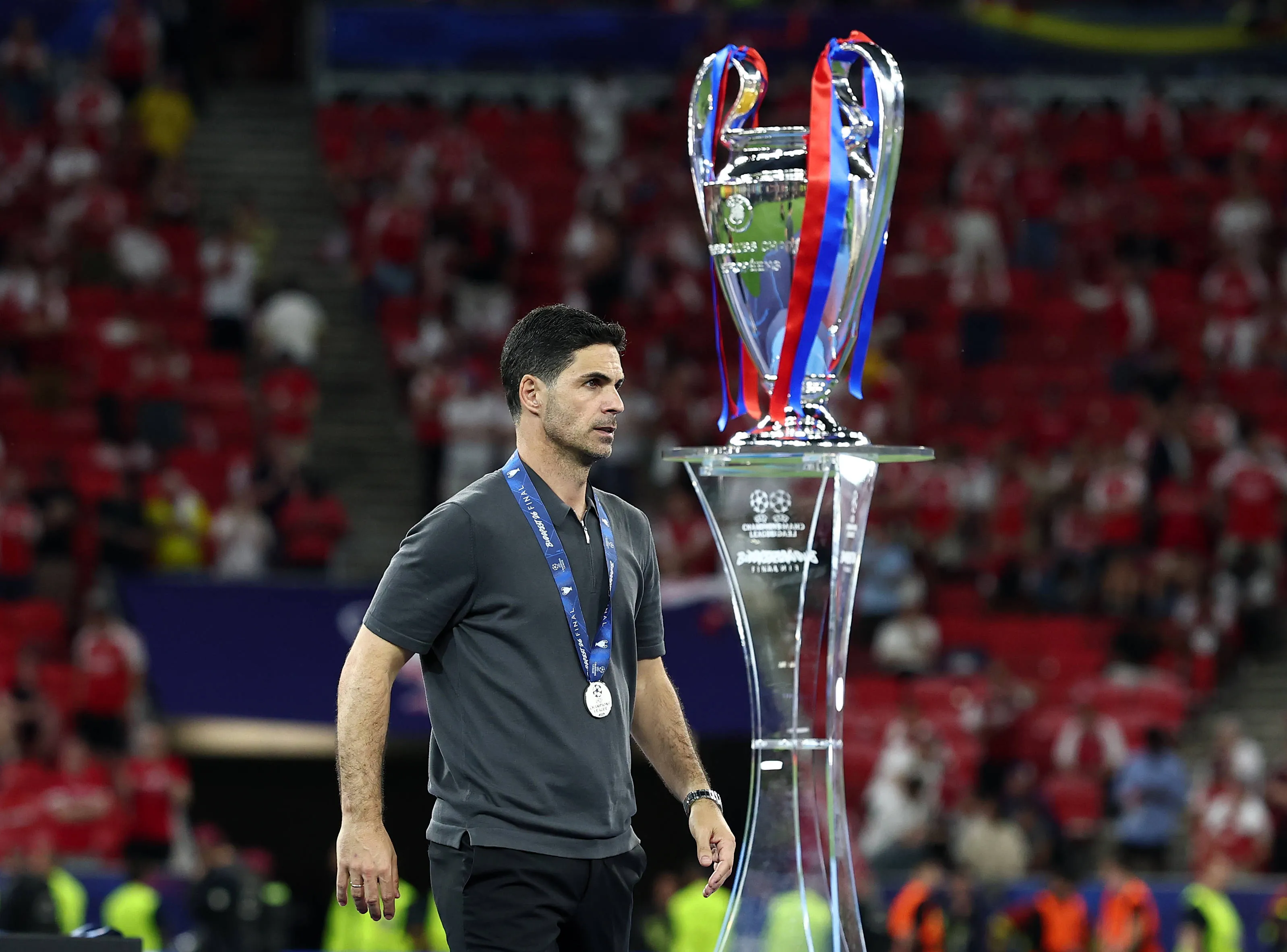 Mikel Arteta manager of Arsenal walks past the UEFA Champions League trophy