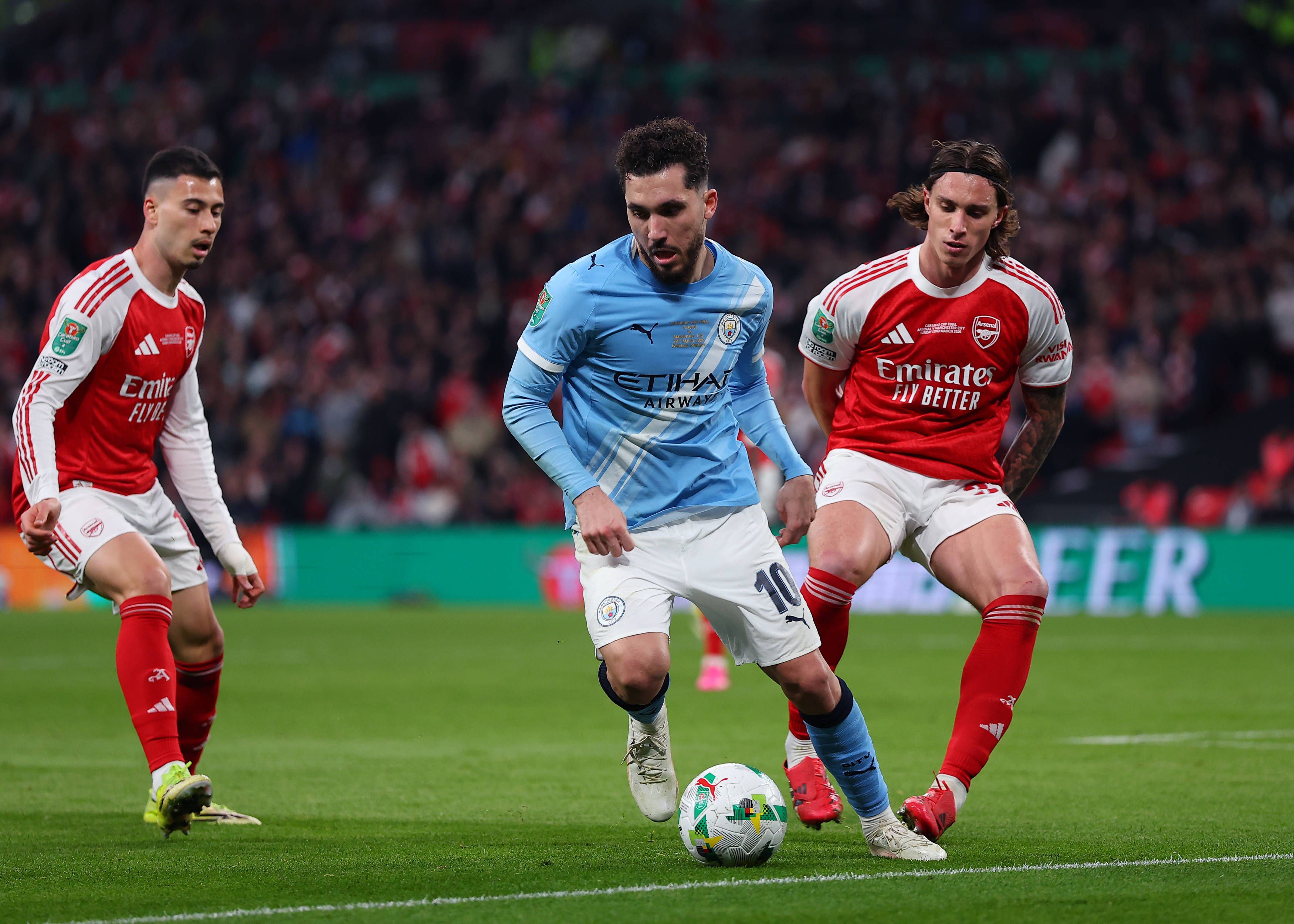 Arsenal versus Manchester City Rayan Cherki of Manchester City under pressure from Riccardo Calafiori and Gabriel Martinelli of Arsenal