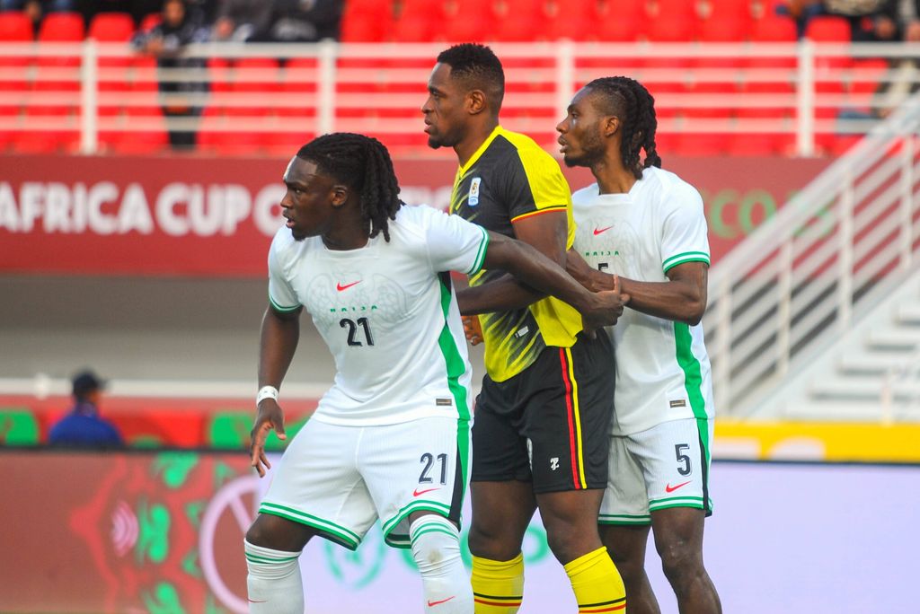 Calvin Bassey and Igoh Ogbu holding off Uche Ikpeazu during the Africa Cup of Nations AFCON match between Uganda and Nigeria