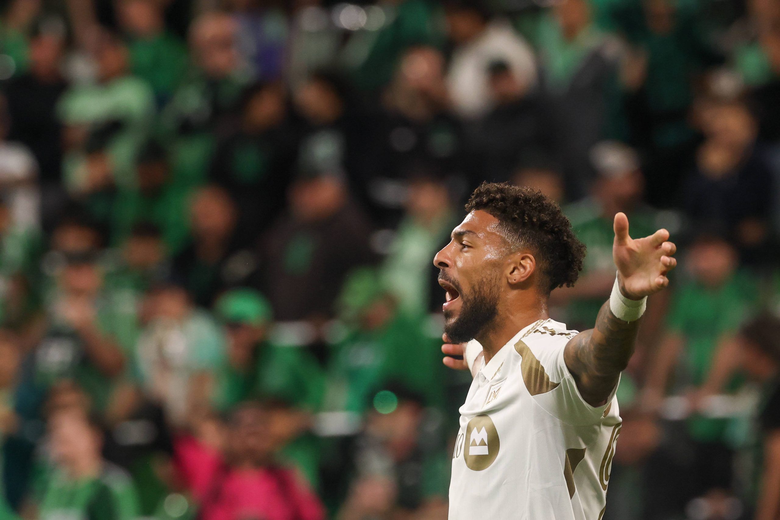 Denis Bouanga holds his arms out wide and screams after scoring a goal during the MLS playoff match between Austin FC and Los Angeles FC