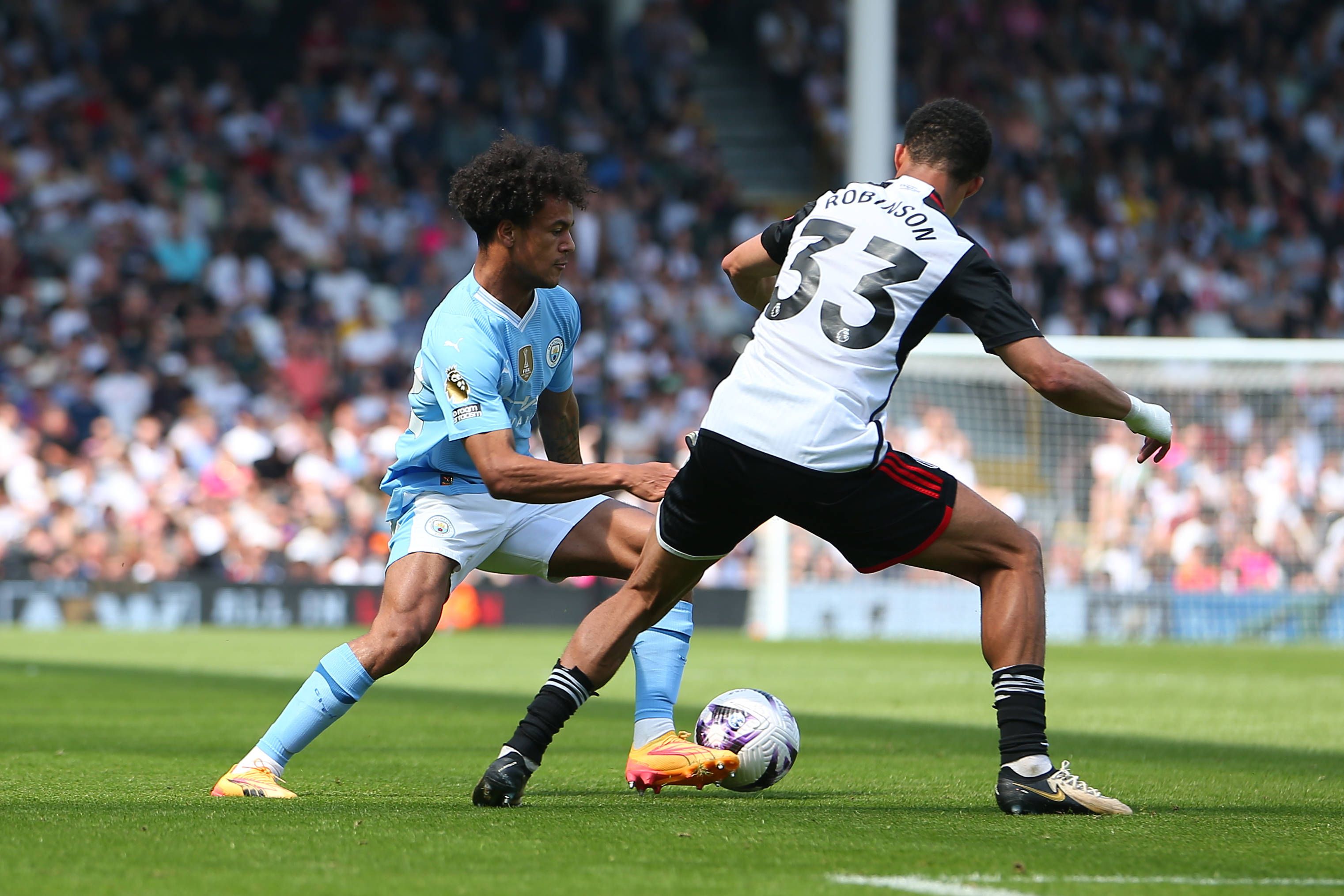 Oscar Bobb takes on Antonee Robinson of Fulham