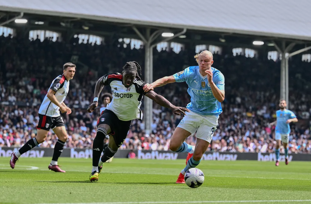 Erling Haaland holds off the challenge from Fulham's Calvin Bassey