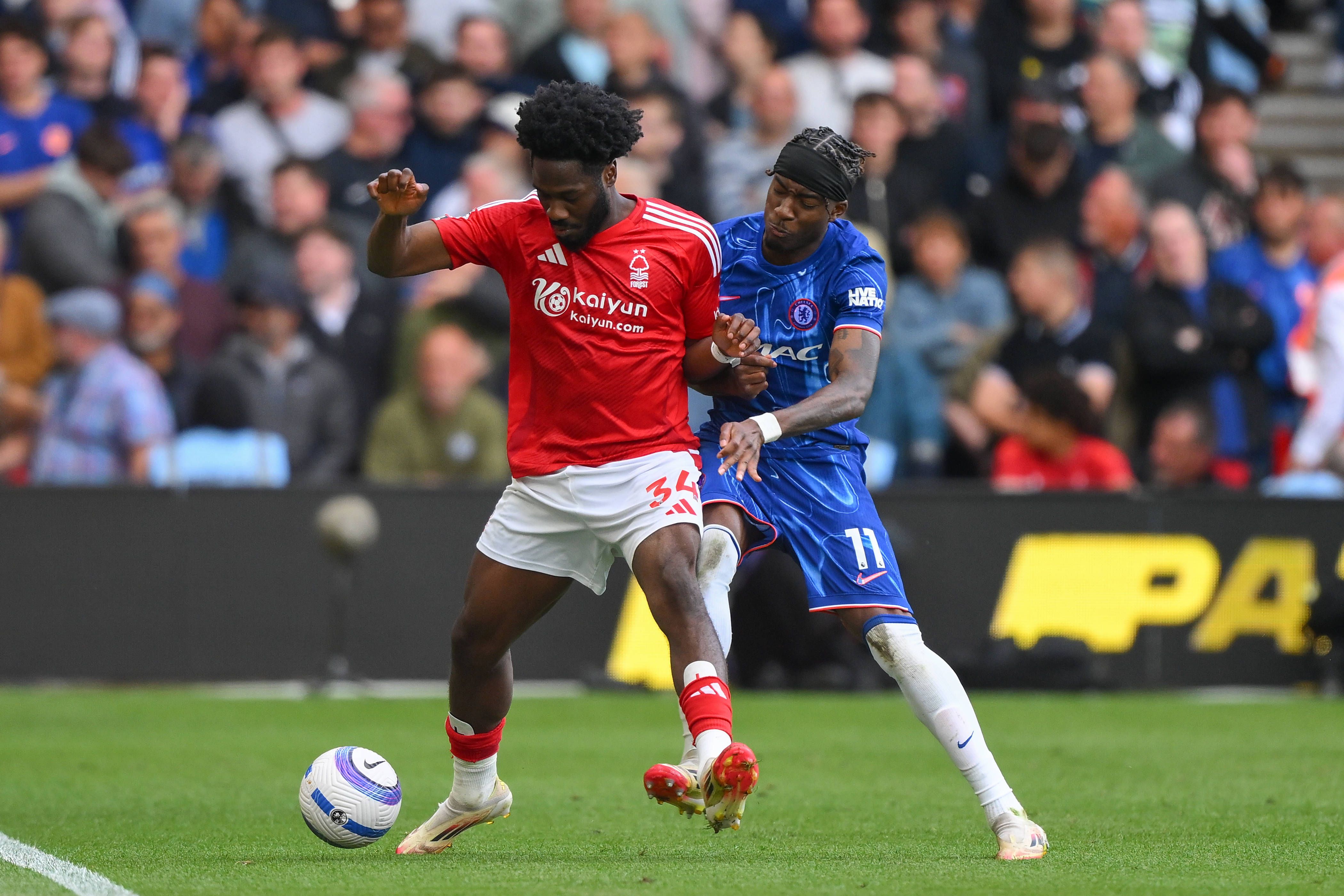 Ola Aina of Nottingham Forest shields the ball from Noni Madueke of Chelsea during the Premier League match between Nottingham Forest and Chelsea at the City Ground, on May 25, 2025
