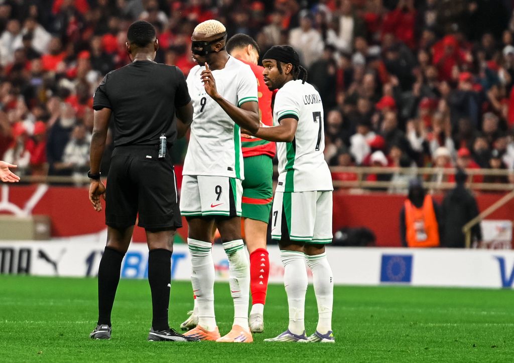 Referee Daniel Nii Ayi Laryea, Victor Osimhen and Ademola Lookman in Nigeria's AFCON 2025 semi-final game against Morocco