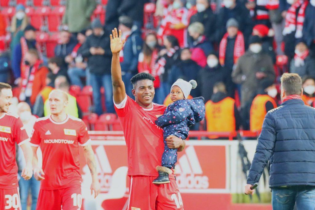 Taiwo Awoniyi takes a lap of honour with his son after scoring against Mainz 05 in the Bundesliga on February 26. Photo by Lolade Adewuyi
